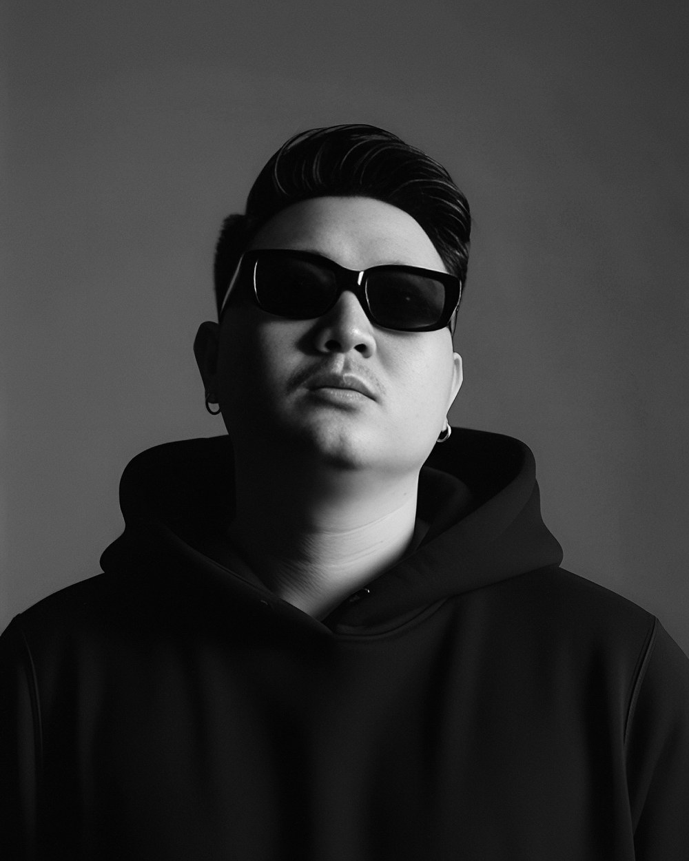 Black and white portrait of D in hoodie and sunglasses