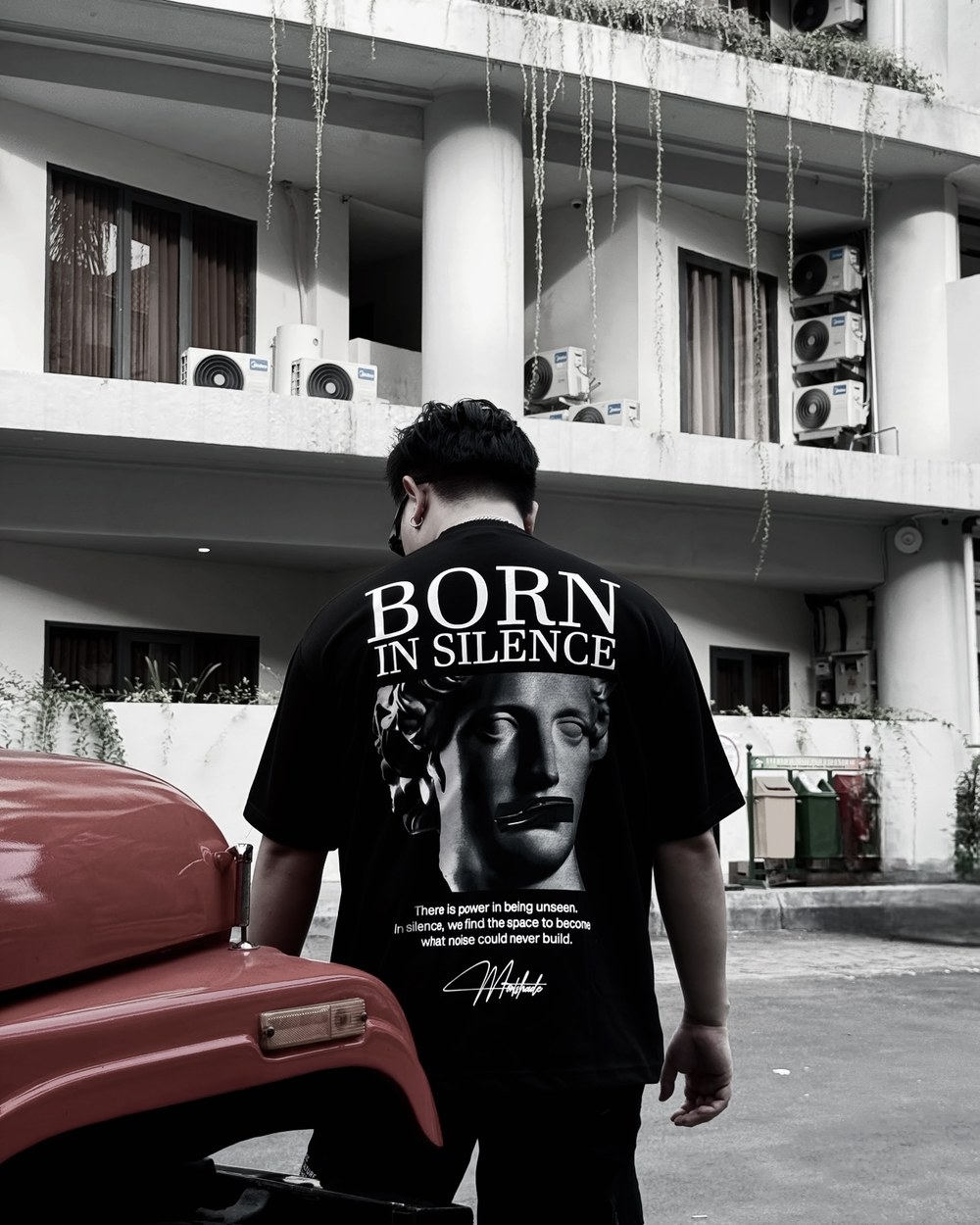 Back view of D wearing Born in Silence shirt